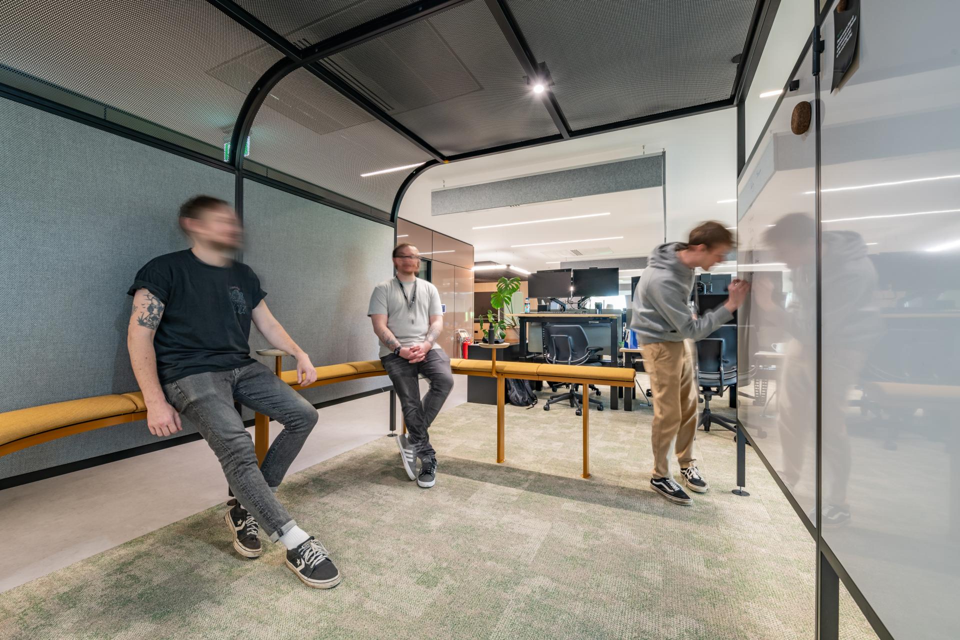 Collaboration space with three individuals in a modern FinTech office, showcasing innovative workplace design by iDEA.