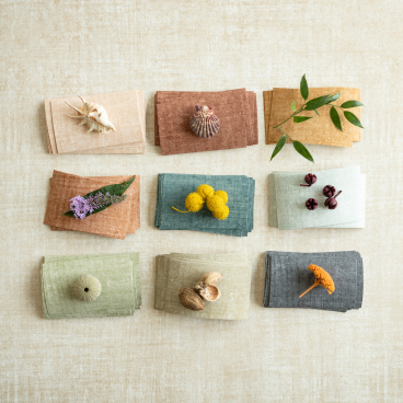 Autumnal fabric swatches in earthy tones with natural elements, showcasing Arte's Brushed Suede and Washed Linen collections.