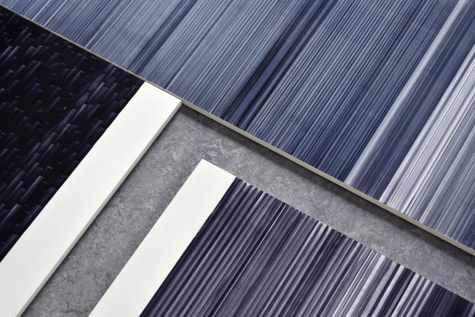 Innovative tile designs by Léa Mazy feature varying blue hues and textures, showcasing the new printing process for the industry.