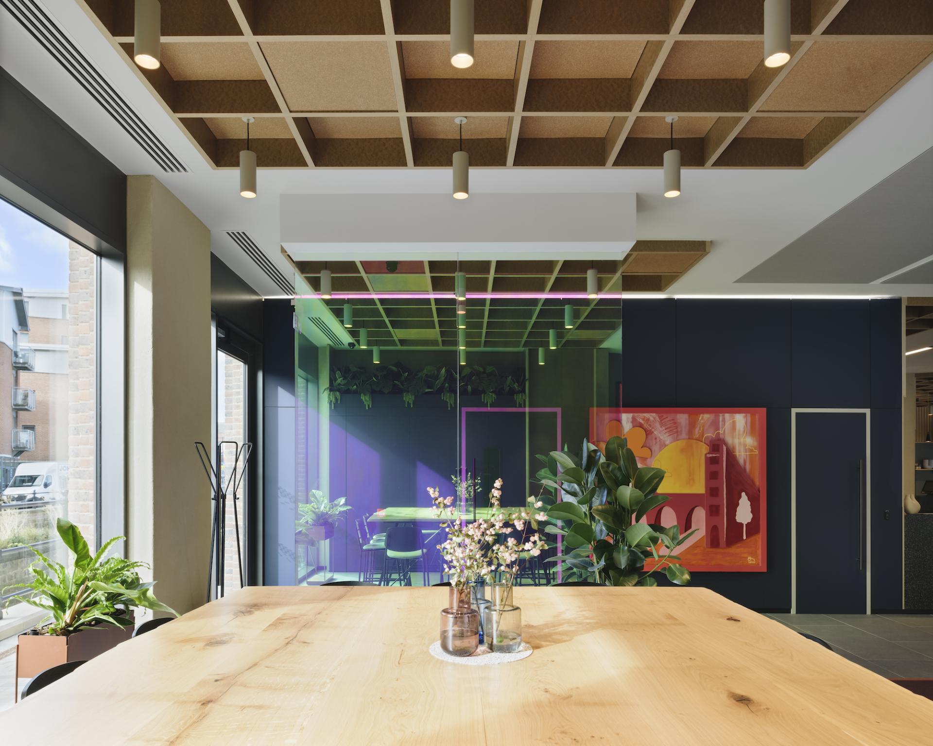 Modern interior design at Globe Point features a wood table, vibrant green walls, and artistic decor by Ekho Studio.