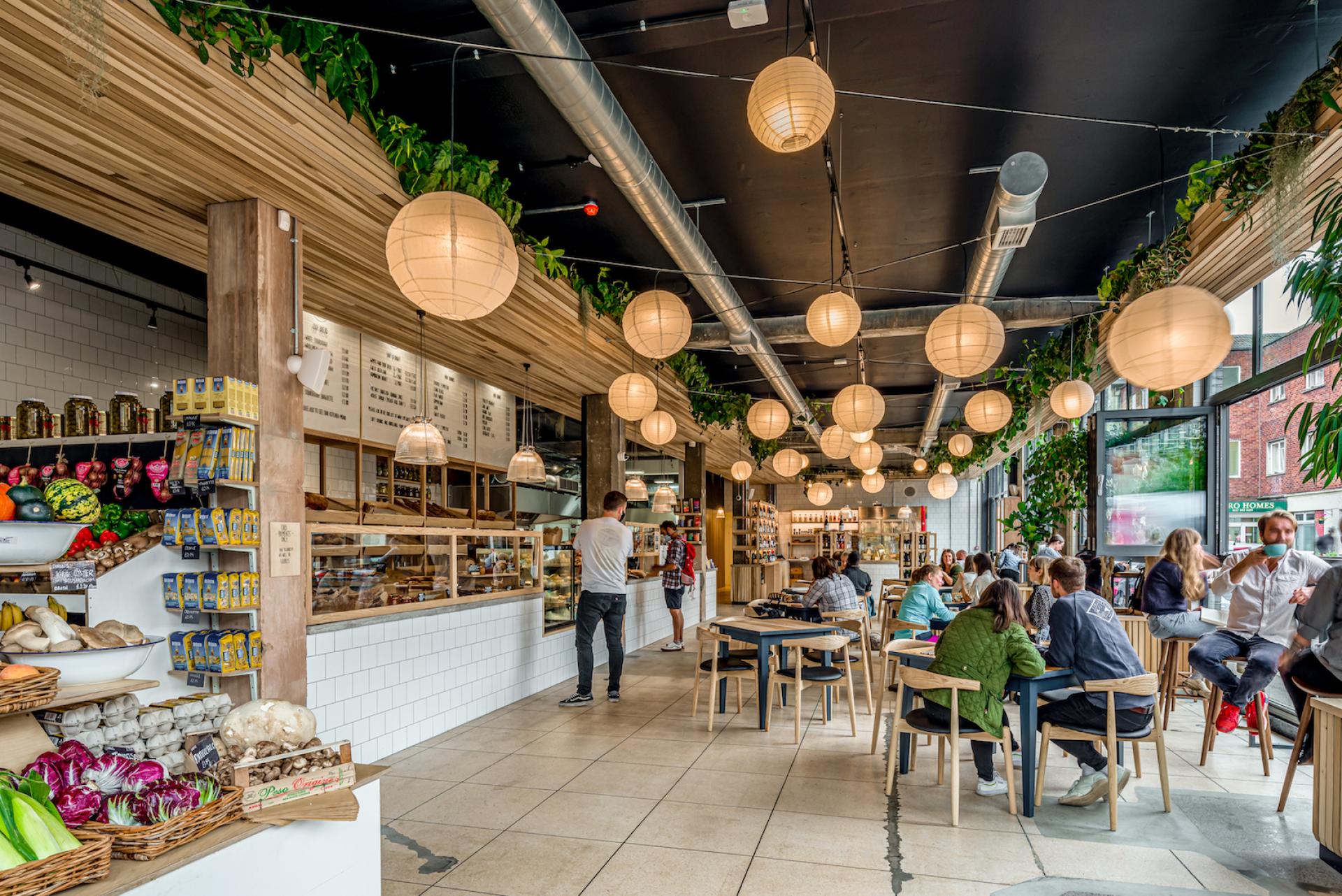 Bright interior of The Bristol Loaf cafe, showcasing natural decor, hanging lanterns, and patrons enjoying their meals.