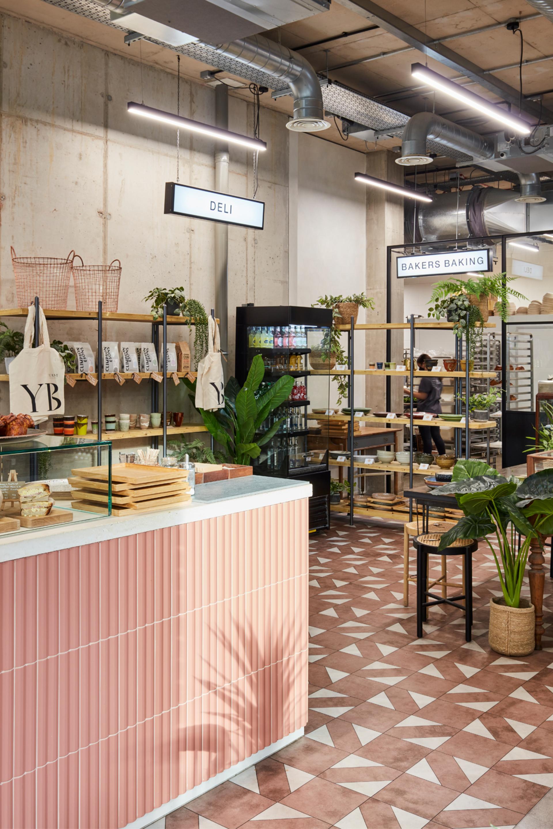Stylish interior of Yeast Bakery with urban artisan design elements, including a deli counter and decorative flooring.