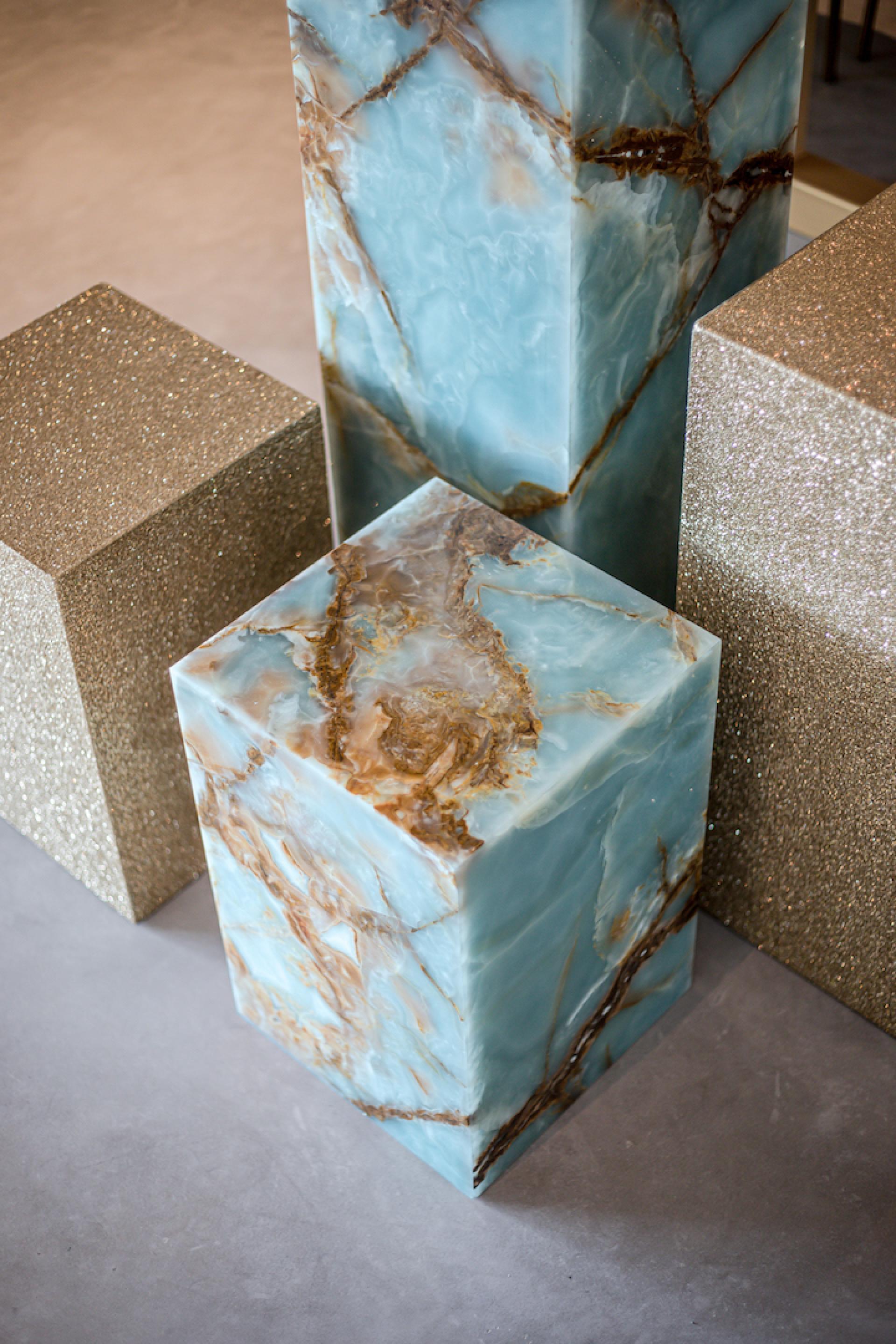Stylish marble furniture pieces in blue and gold enhance the modern aesthetic of the Reinders showroom.