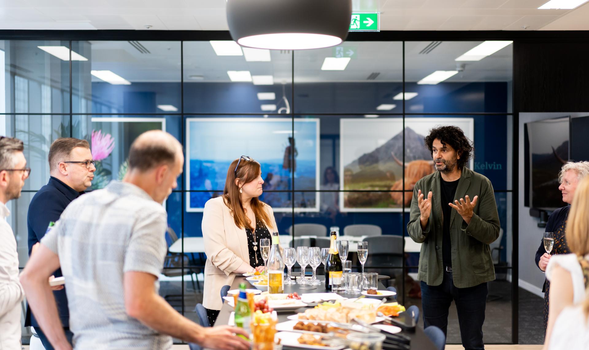 Professionals engaging in conversation over refreshments in a modern office, highlighting collaboration in a forward-thinking workplace.