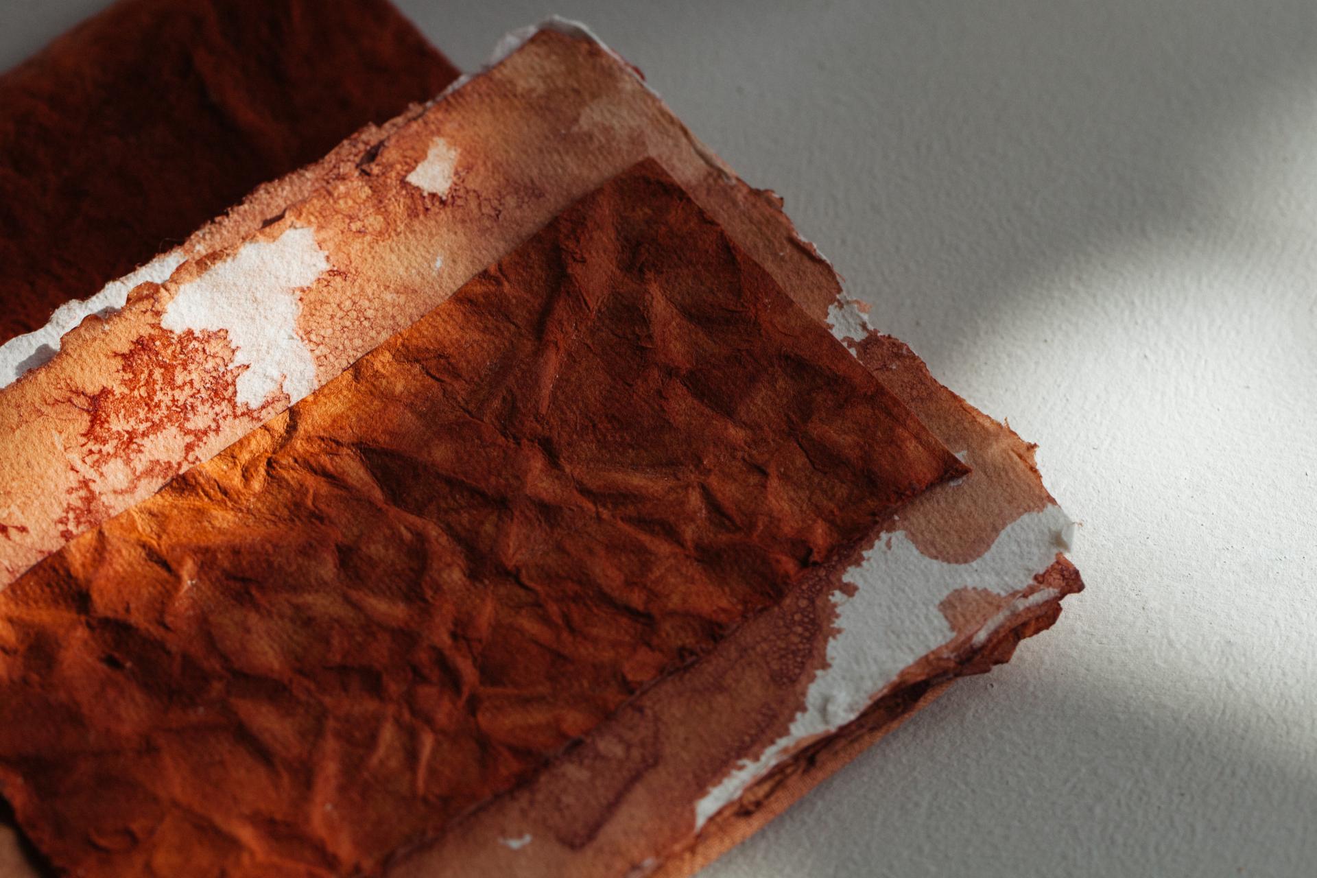 Textured, orange-hued fabric representing innovative color techniques in sustainable design and circular materials.