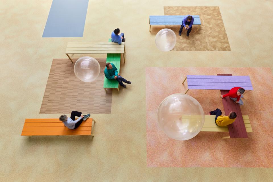 Vibrant Modul’up flooring with diverse textures and colors, showcasing collaborative spaces and nature-inspired design elements.