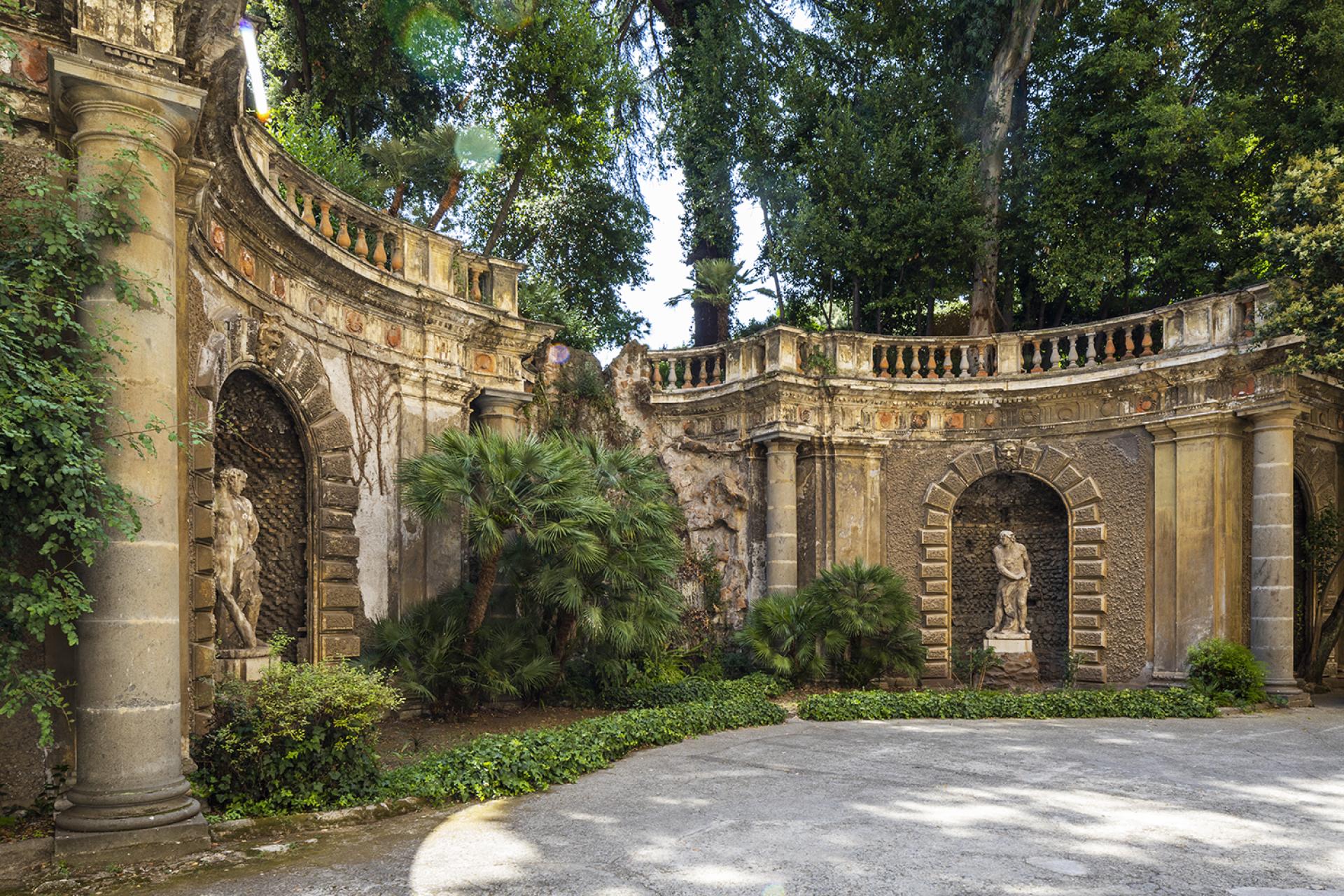 Historic courtyard at Palazzo Brancaccio featuring ancient sculptures and lush greenery, highlighting Contemporary Cluster's new art space in Rome.
