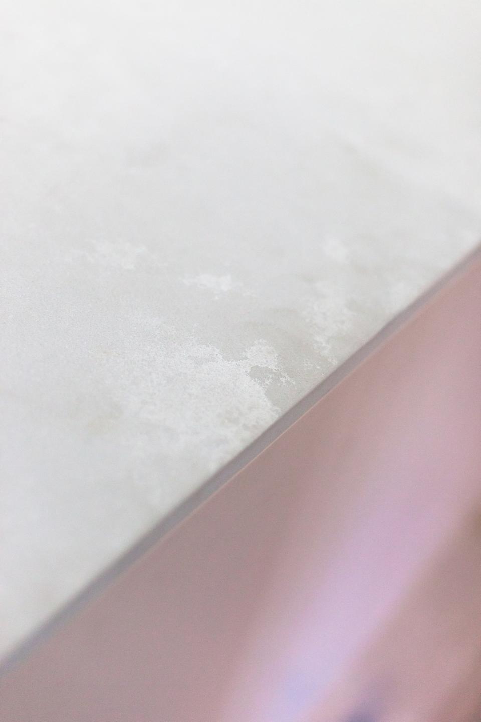 Textured surface of a light-colored kitchen countertop showcasing modern design by 2LG Studio for home interiors.