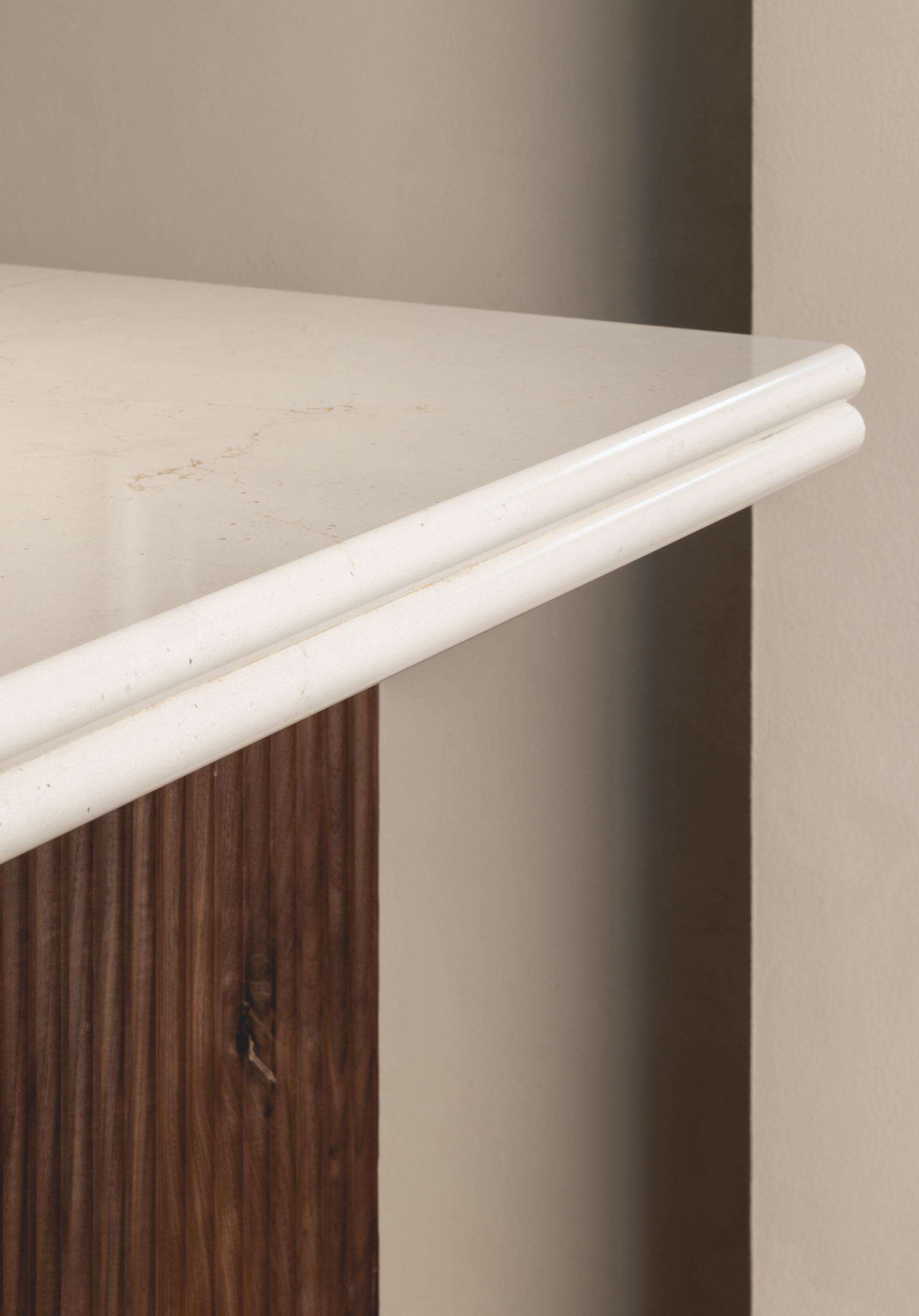 Elegant marble countertop with rounded edges, complementing the warm wood cabinetry in Honey & Co's Bloomsbury restaurant interior.