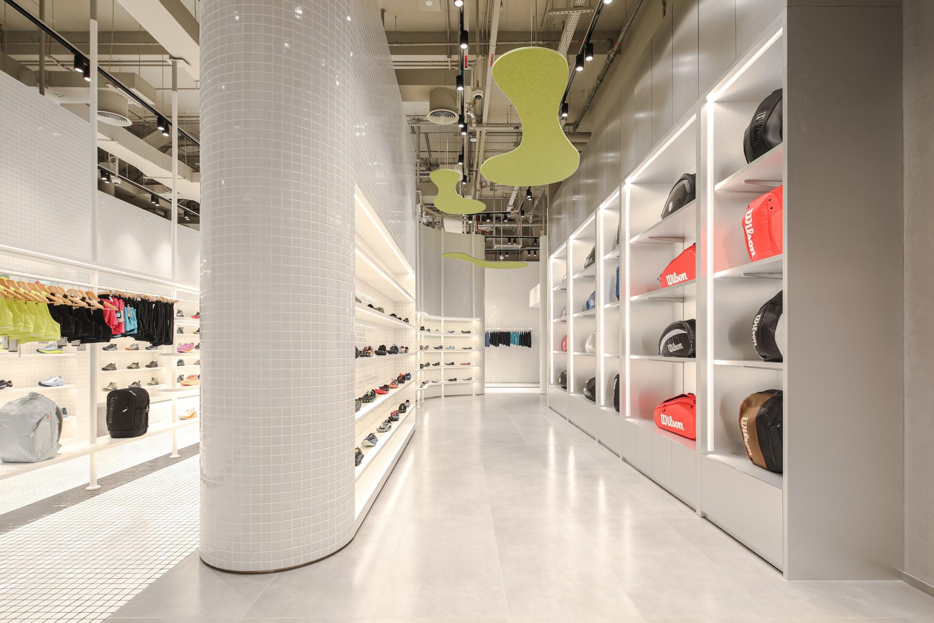 Modern underground store interior showcasing vibrant activewear, stylish shoes, and colorful gym bags in Dubai.