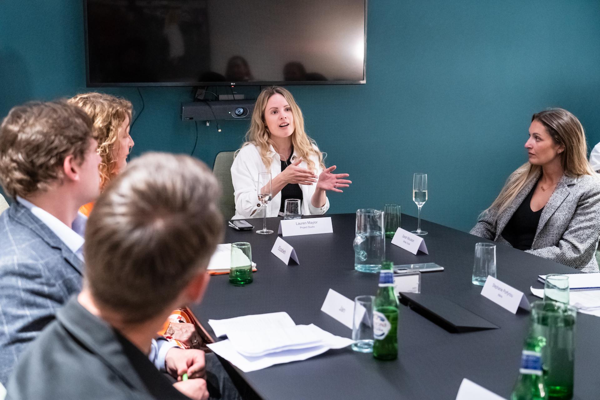 Roundtable discussion on Manchester's property sector featuring diverse participants engaging in conversation about BTR and co-living trends.