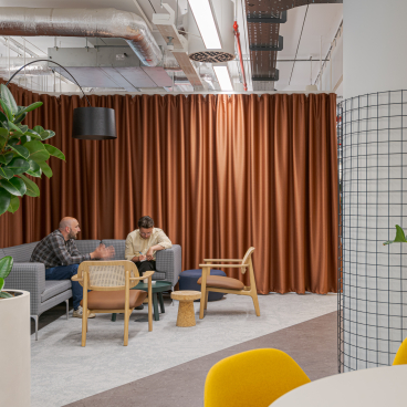 Collaborative workspace design by Modus, featuring seating areas, plants, and a warm color palette at Landsec's headquarters.