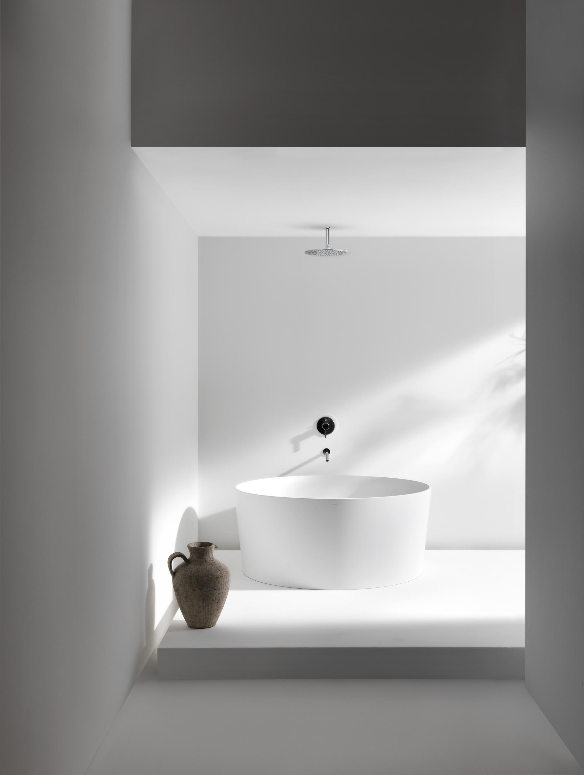 Modern LAUFEN bathtub elegantly positioned in a minimalist bathroom, showcasing sleek design elements and natural light.