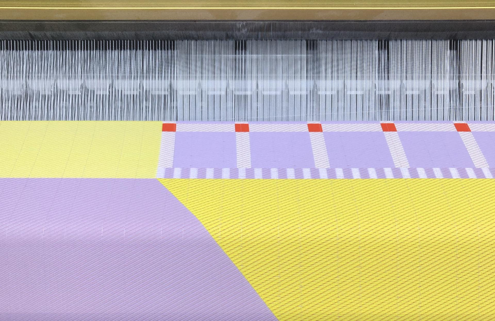 Colorful textile design process showcasing woven patterns in a textile factory, highlighting biotechnological applications in interiors.