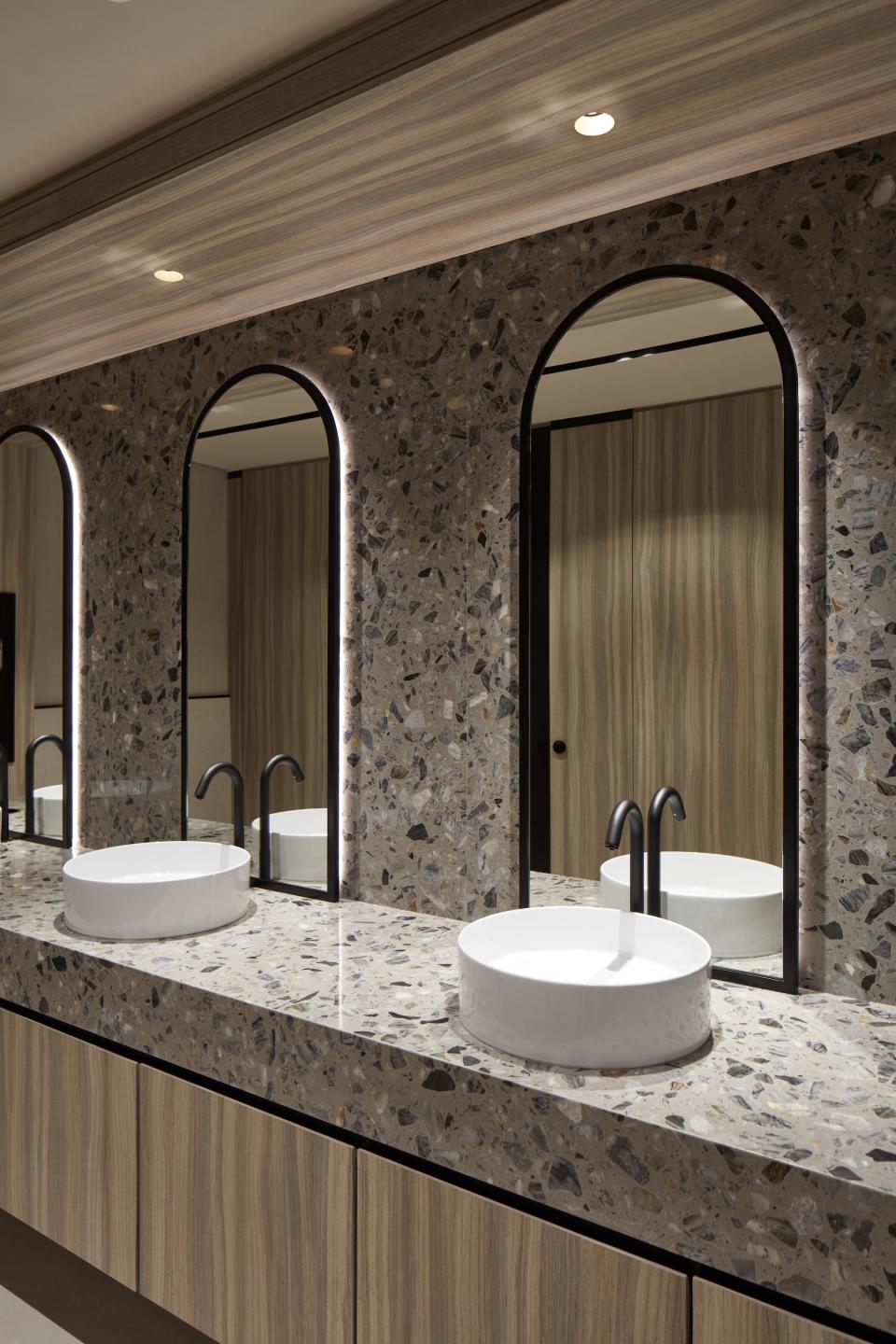 Elegant restroom design with marble sink, unique terrazzo countertop, and modern mirrors in Dubai Internet City offices.