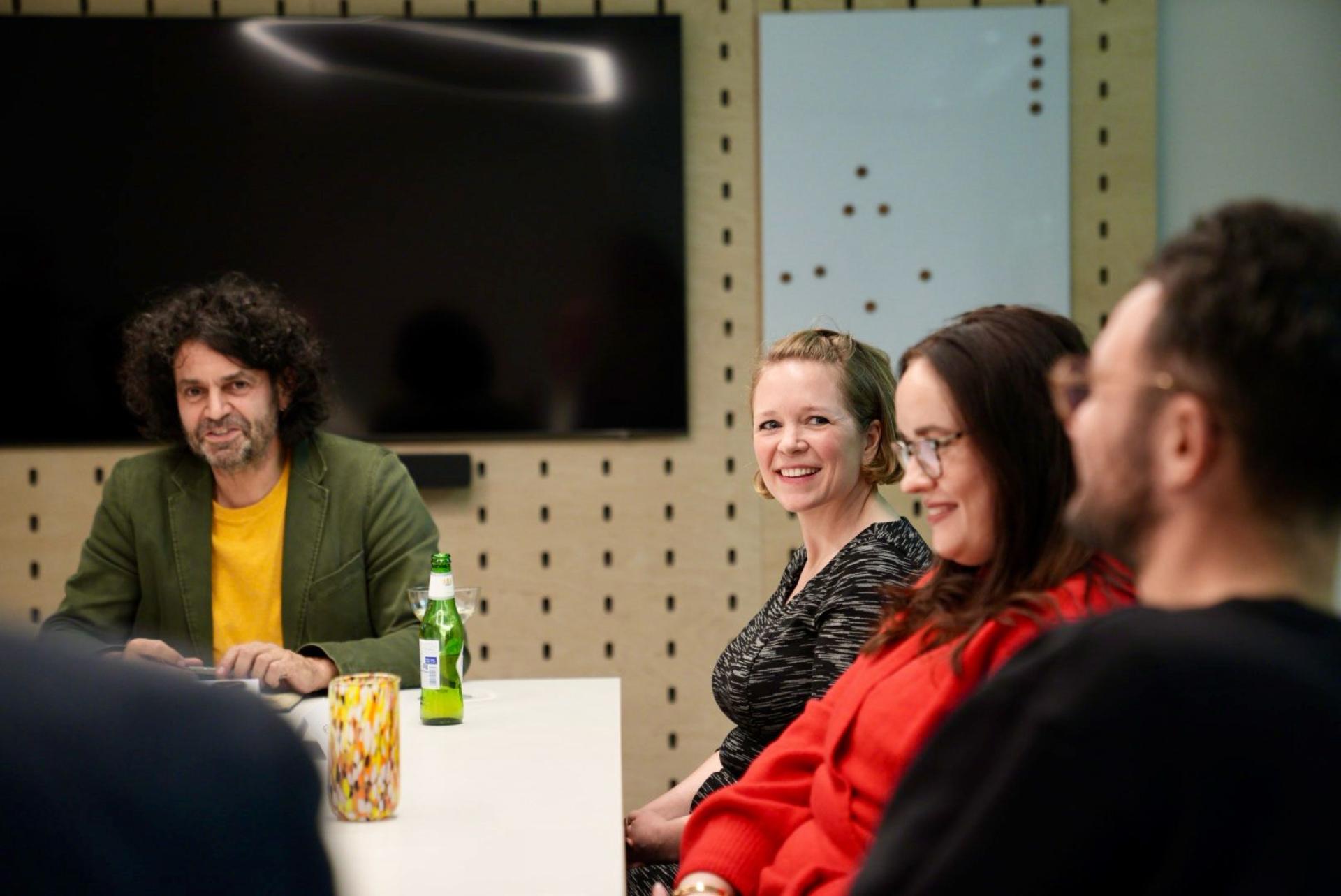A diverse group of colleagues engaging in a discussion about future workplace flexibility in a modern office setting.