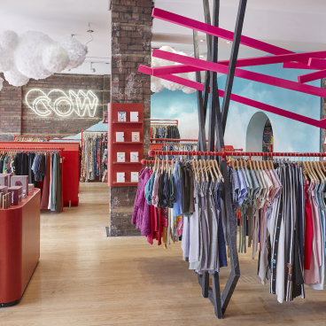 Colorful vintage clothing racks and vibrant displays inside COW's new flagship store in Leeds, showcasing a trendy shopping environment.