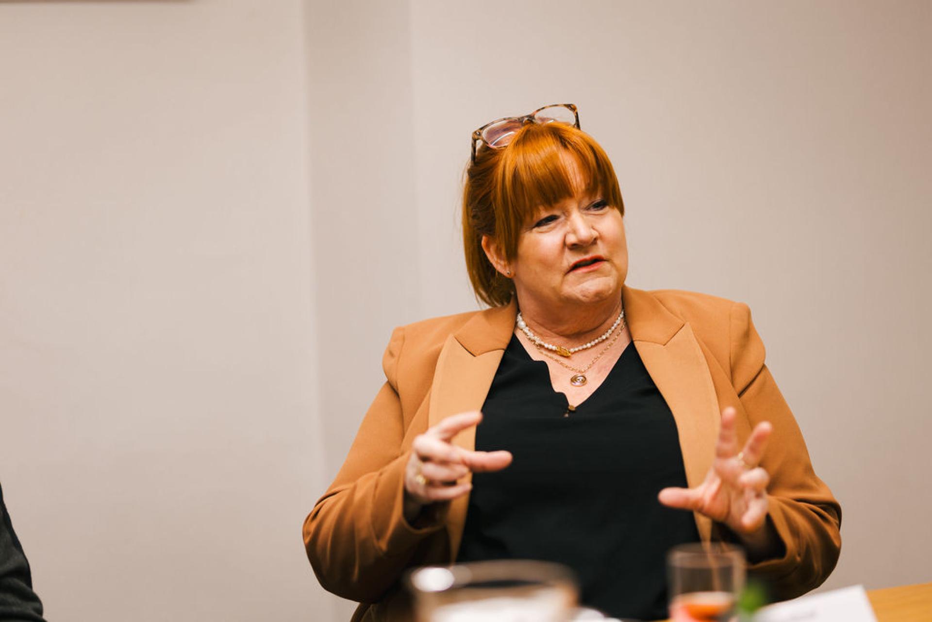 Discussion on Glasgow's property market featuring a speaker in a brown blazer, engaging in conversation.