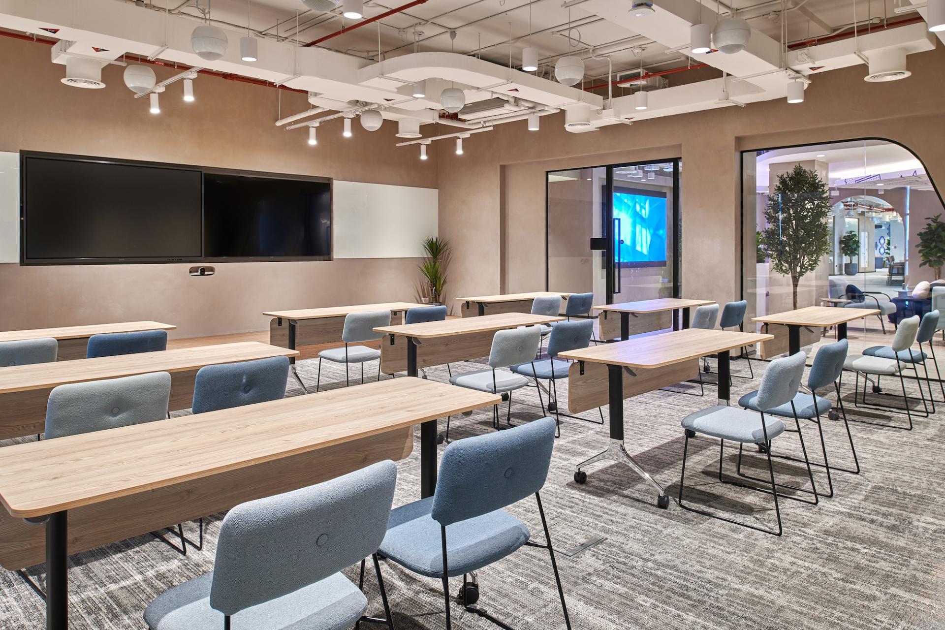 Modern classroom setup at Sharjah Entrepreneurship Center featuring desks, chairs, and advanced technology for collaborative learning.