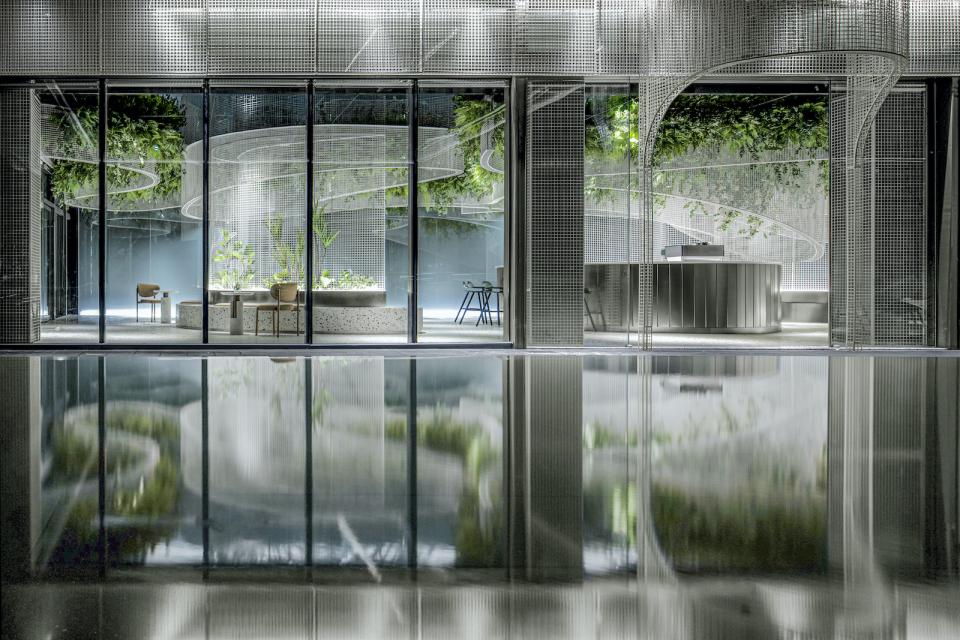 Modern café interior featuring terrazzo surfaces, curved mesh design, and lush greenery, highlighting the Vista concept by Karv One.