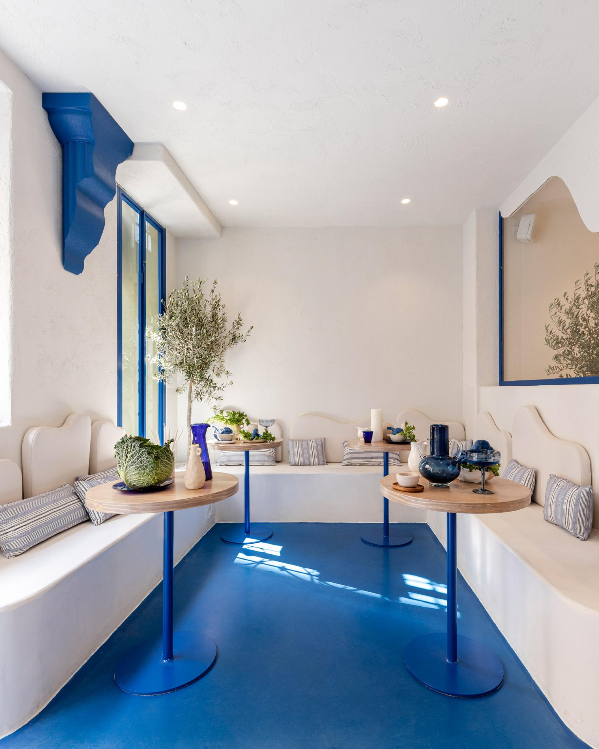 Bright and airy interior of Egeo restaurant, featuring blue accents, comfortable seating, and Mediterranean-inspired decor elements.