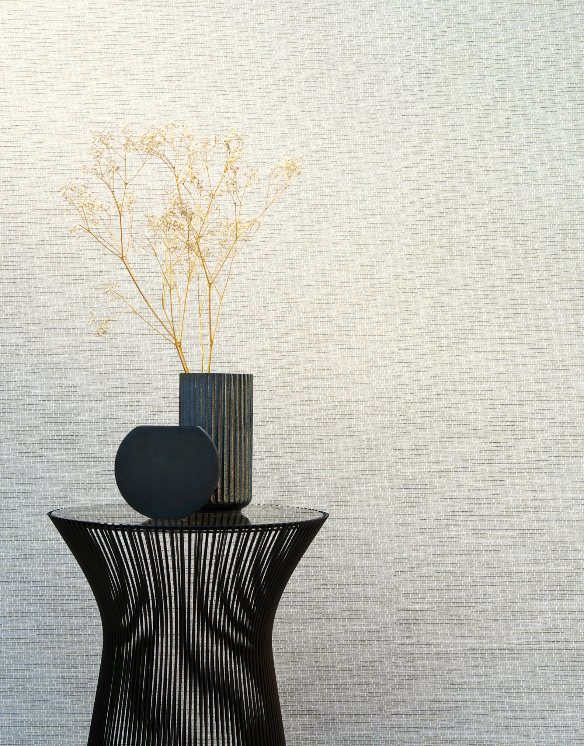 Geometric decorations with modern vases and dried flowers against a textured wall, showcasing Arte's Totem wallcoverings collection.