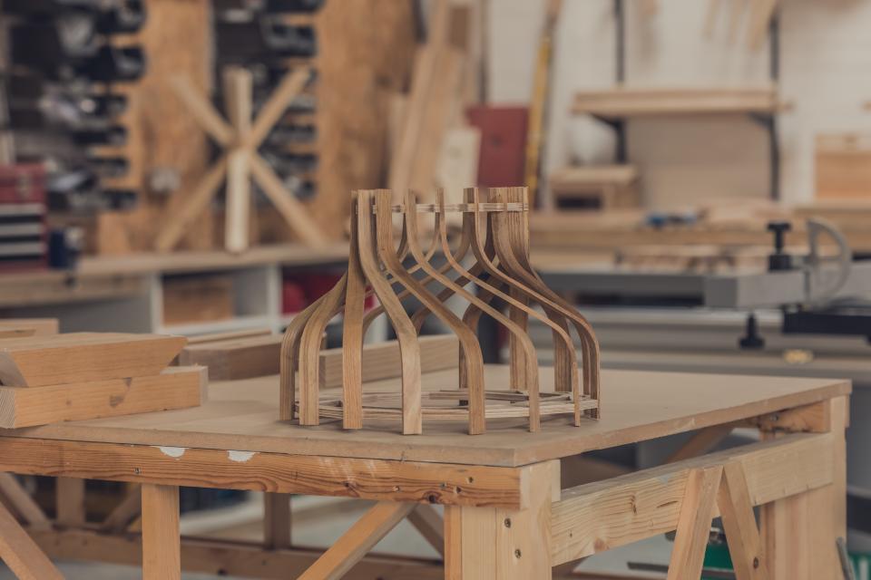 Bespoke wooden lampshade frames on a workbench, inspired by the art deco hippodrome design in Wrexham.