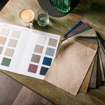 Colorful swatches of Agua Fabrics' Eden and Bouclé upholstery collections displayed on a stylish tabletop.