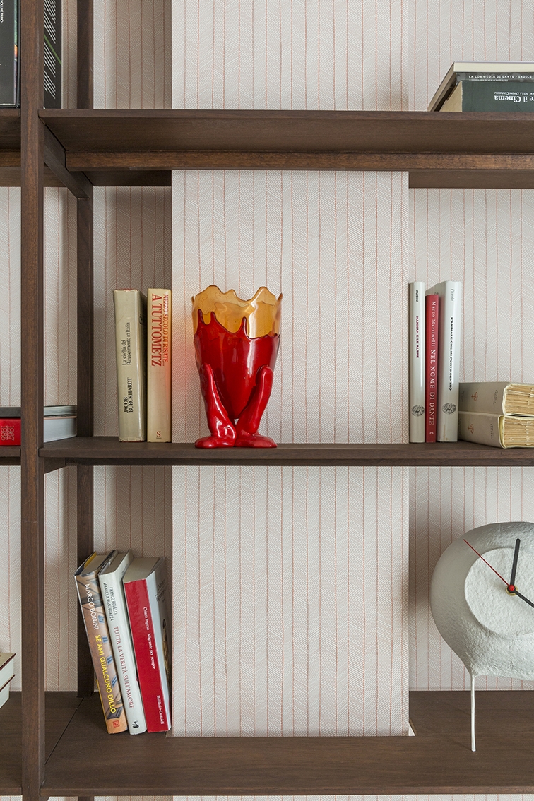 Guest bedroom. Wall bookcase with wengé wood veneer custom designed by Alvisi Kirimoto; wallpaper by Metamorphosi; ceiling lights Le Perroquet by IGuzzini; Pendule clock by Papier à étres for Serax; Fish vase design Gaetano Pesce. ©Serena Eller Vainicher