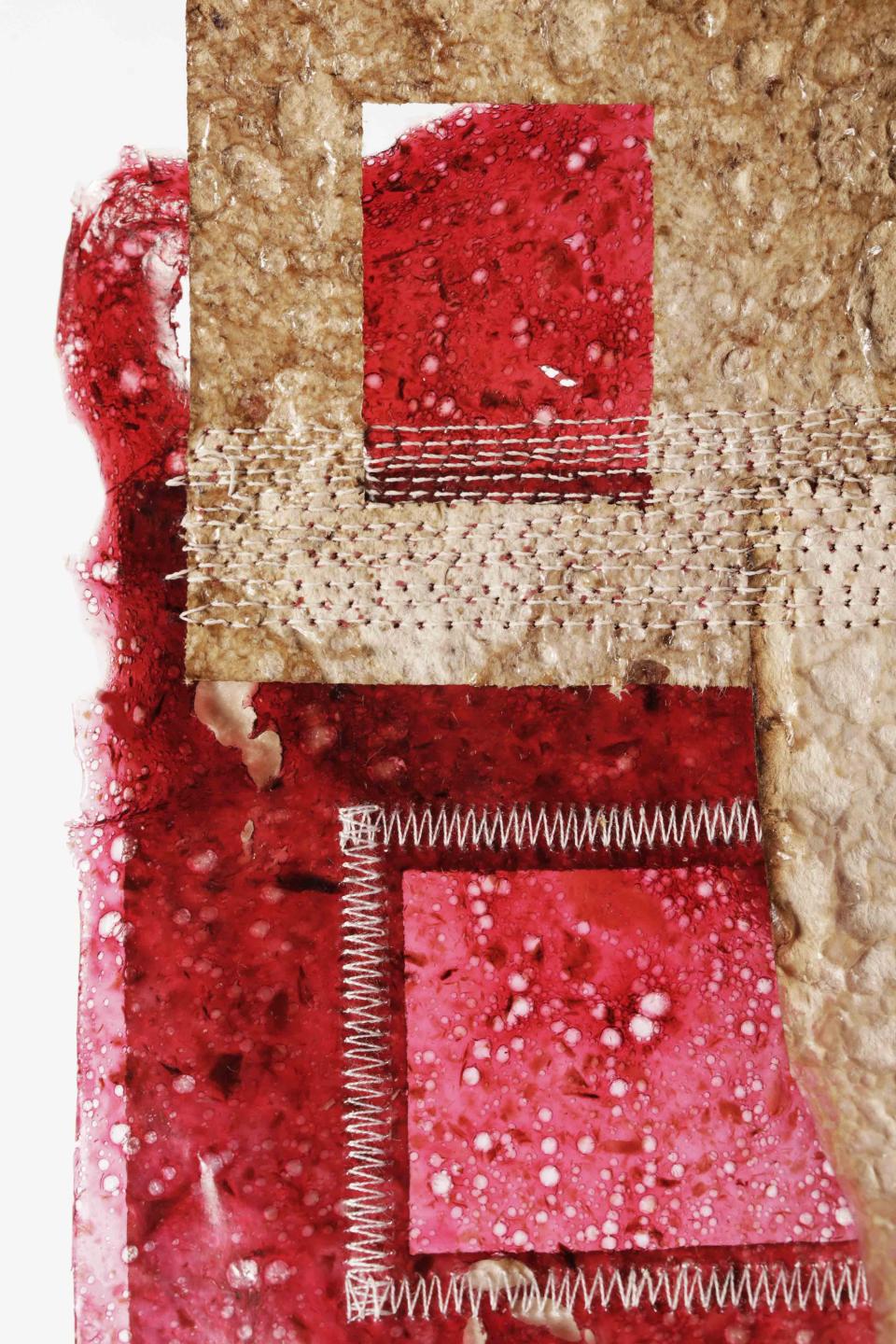 A close-up of layered BioMarble material showcasing vibrant red textures with unique, biodegradable properties.