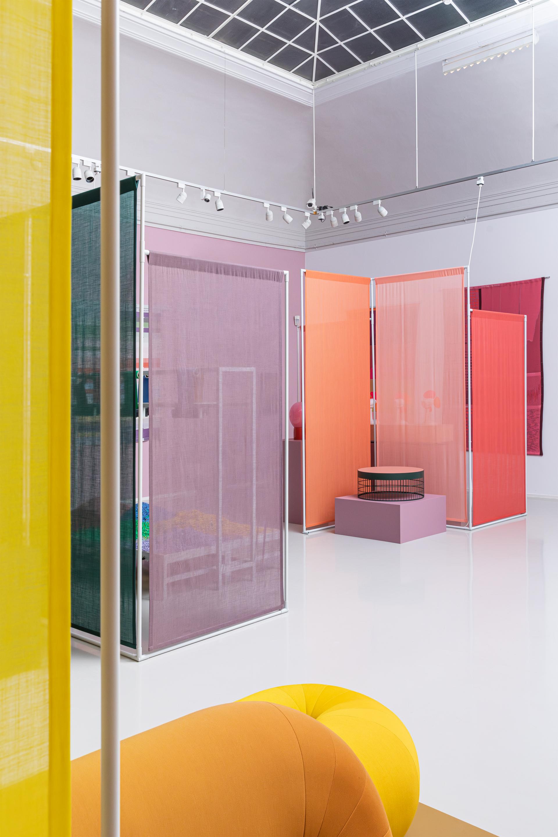 An art installation featuring bio-based color palettes, showcasing colorful partitions and innovative materials in a bright space.