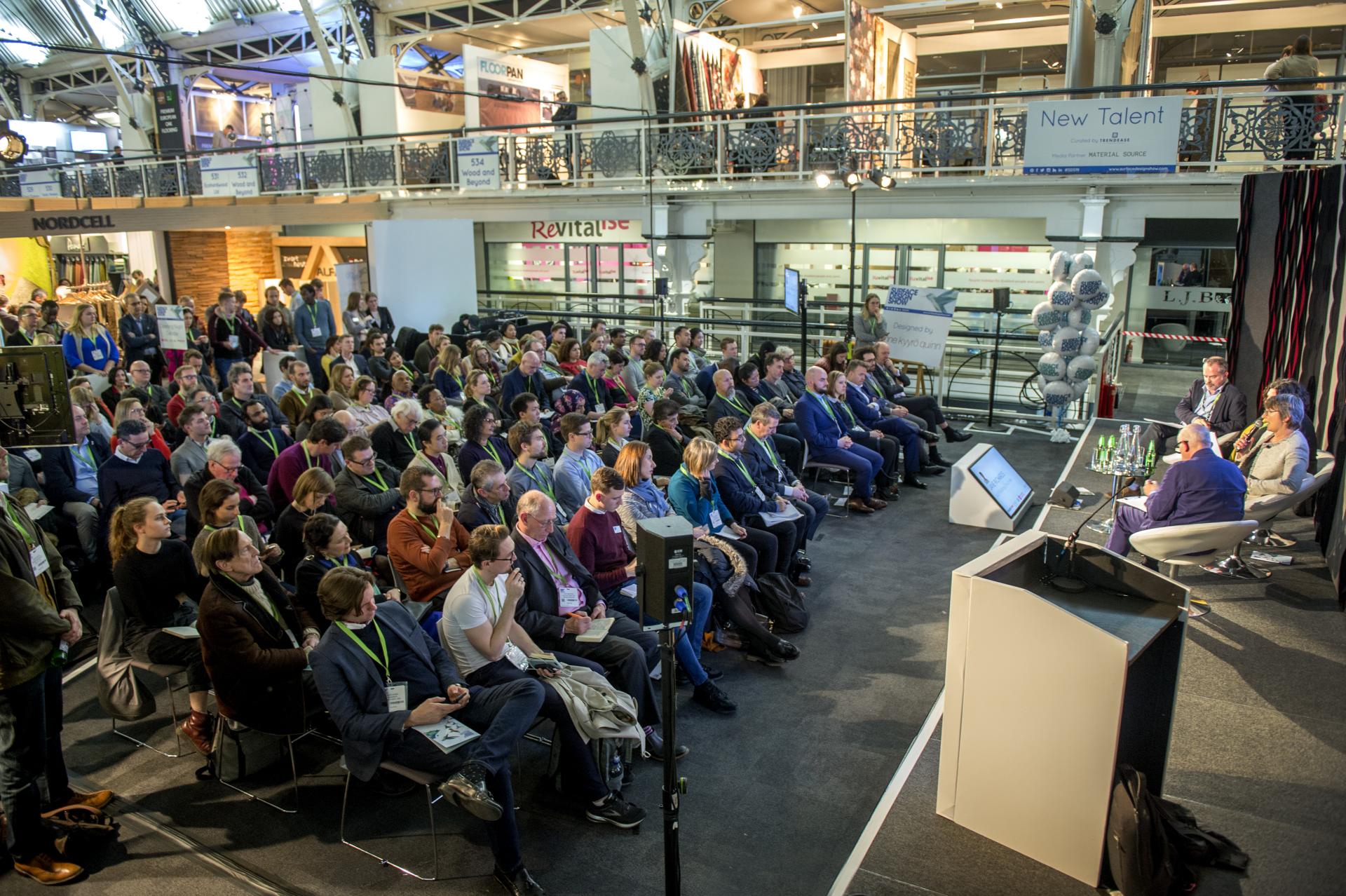Audience engaging at the 2020 Surface Design Show, featuring speakers discussing innovative surface design trends in London.
