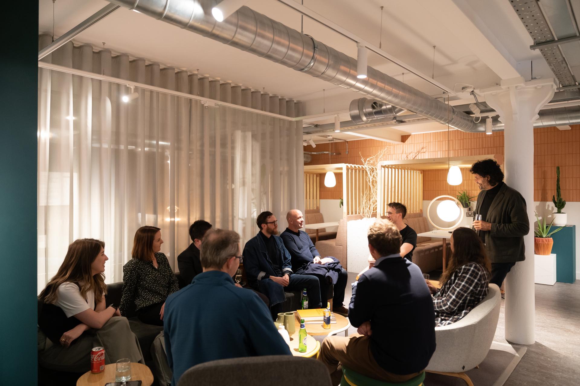Participants engage in discussion during a technology seminar in a modern, stylish workplace environment.