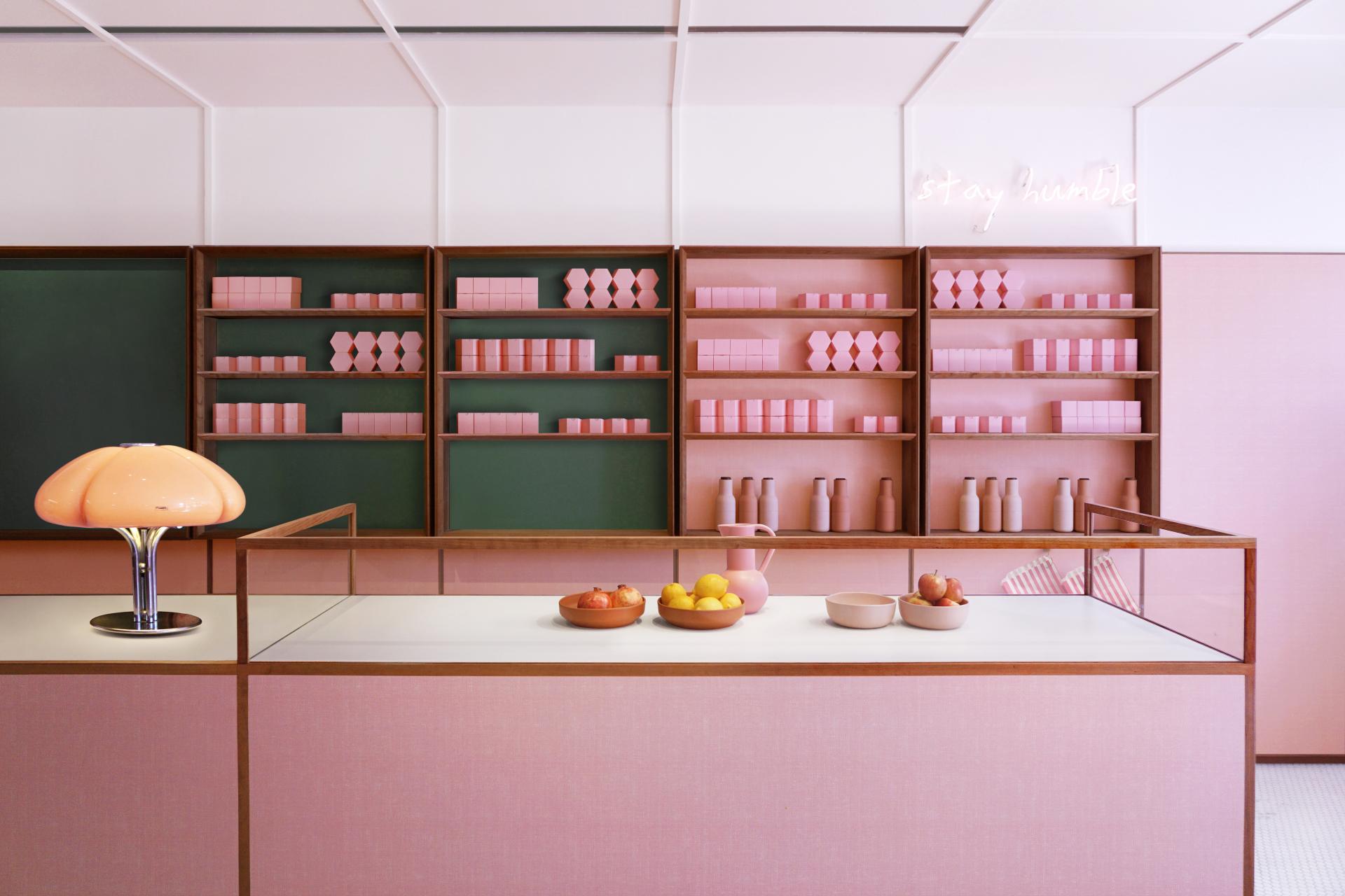 Contemporary 1950s-inspired café interior featuring dusky-pink decor, geometric shelves, and stylish lighting on King’s Road.