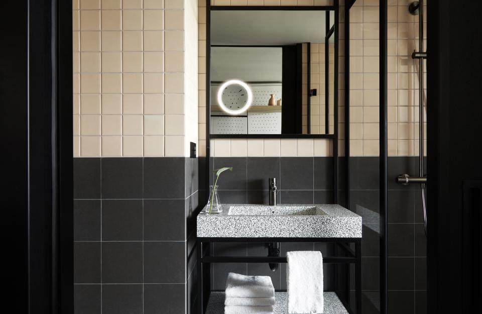 Modern bathroom designed by Conran+Partners featuring terrazzo sink, elegant tiles, and minimalist decor at PURO Kraków Kazimierz.