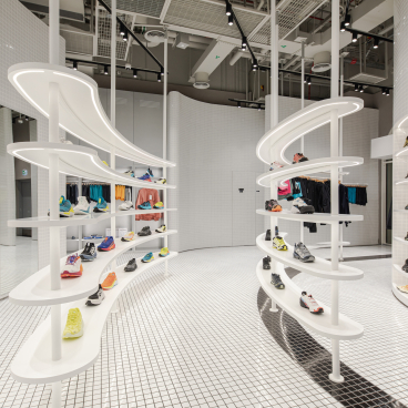 Interactive concept store in Dubai showcasing vibrant, fluorescent activewear and athletic shoes on modern display fixtures.