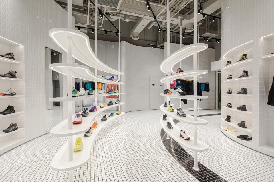 Interactive concept store in Dubai showcasing vibrant, fluorescent activewear and athletic shoes on modern display fixtures.