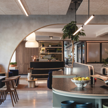 Sophisticated workspace featuring Art Deco-inspired curves, calming colors, and greenery in a modern design layout.