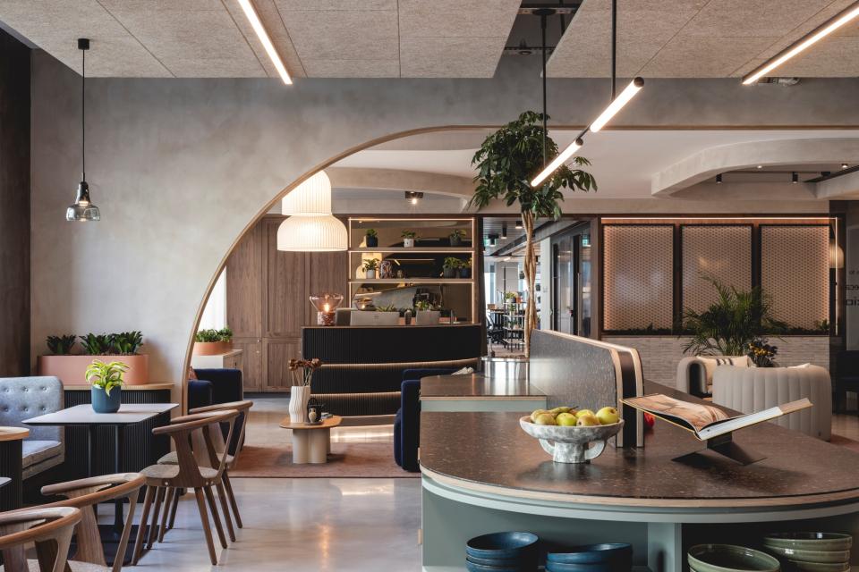 Sophisticated workspace featuring Art Deco-inspired curves, calming colors, and greenery in a modern design layout.