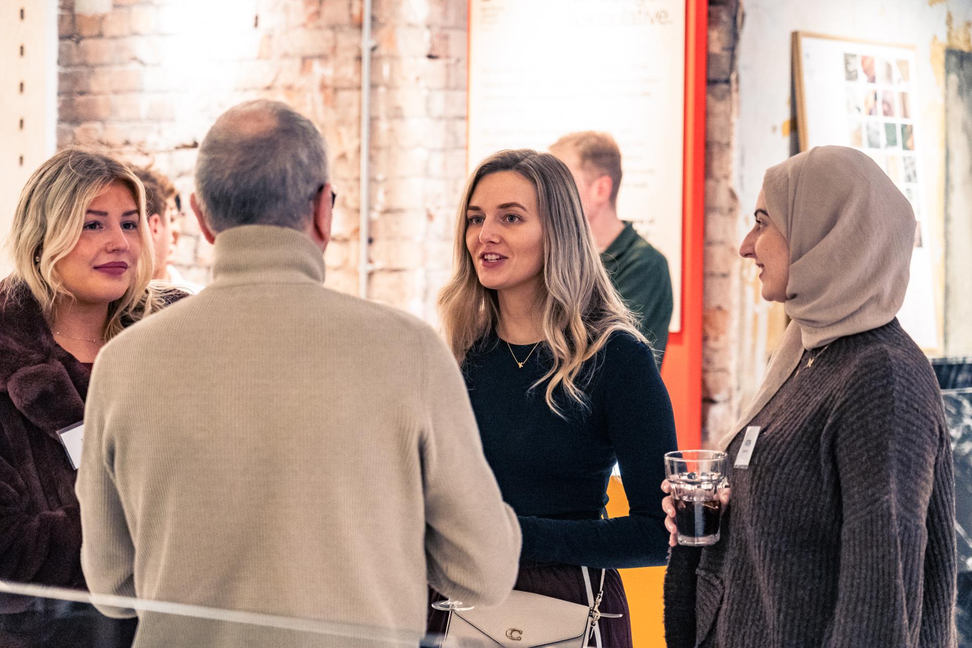 Group of diverse individuals engaging in conversation at a Net Zero sustainability event.