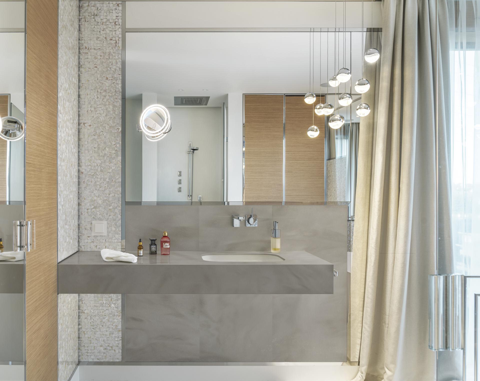 Modern bathroom featuring a sleek Corian countertop, stylish lighting, and elegant decor elements for contemporary design.