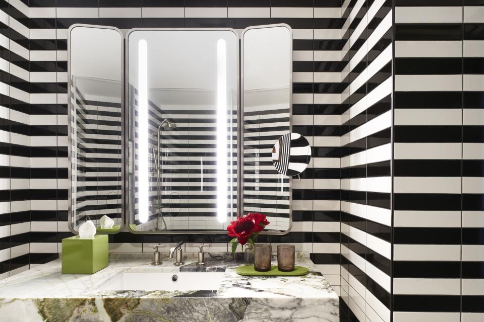 Stylish black and white striped bathroom featuring modern fixtures and vibrant decor by Yabu Pushelberg at Park Lane New York.