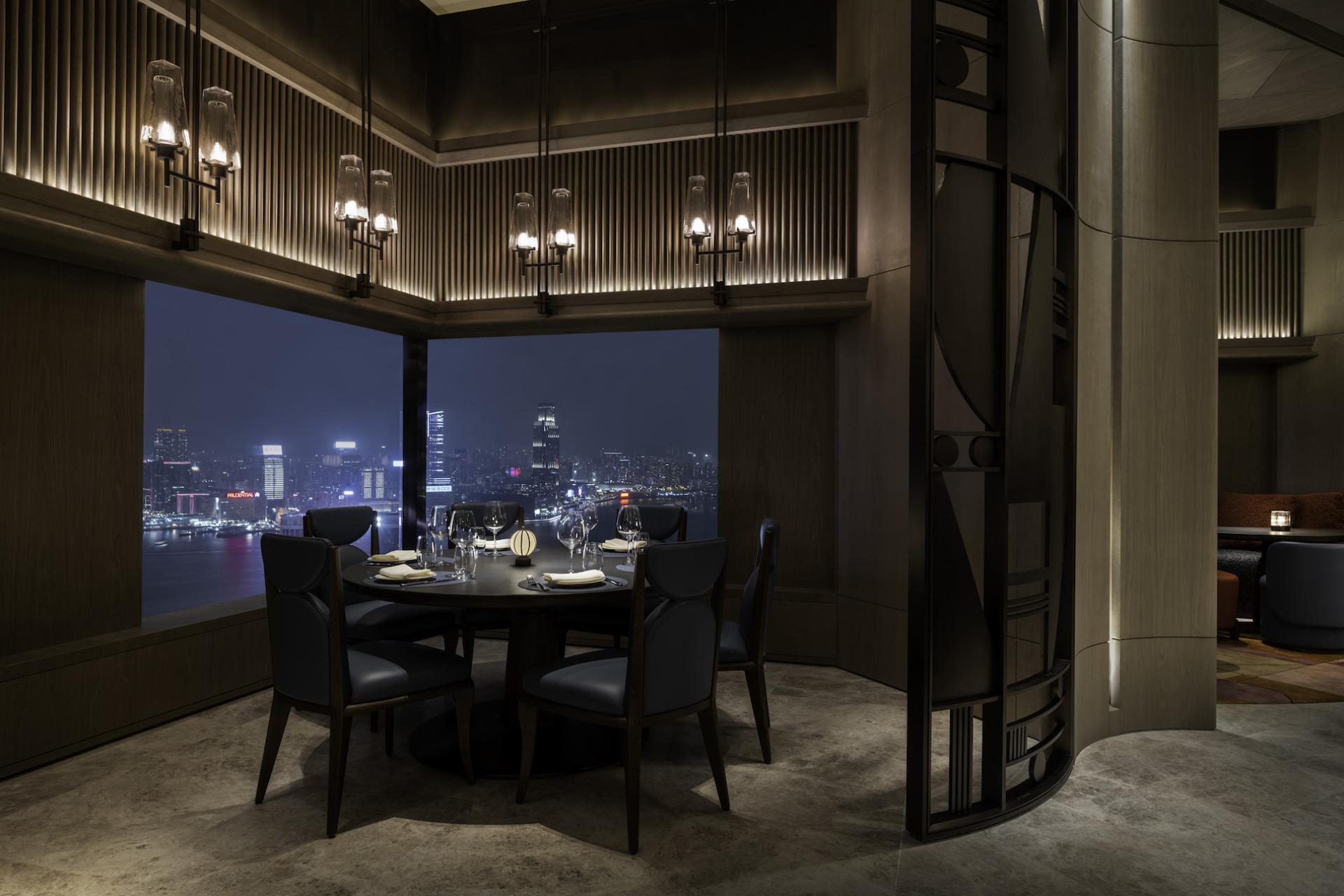 Sophisticated dining room in The Upper House, featuring Art Deco design and stunning city views at night.