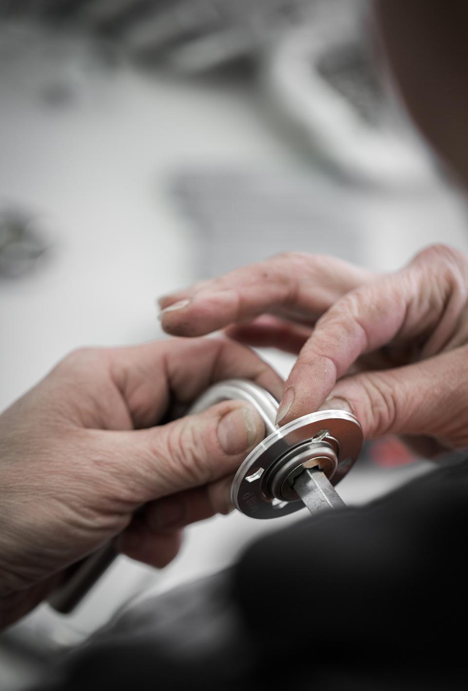 Hands assembling d line's Re-handle® hardware, showcasing sustainable design methods to reduce CO2 emissions.