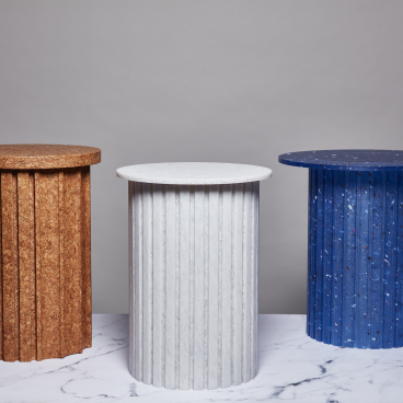 Three unique cylindrical tables in earthy, white, and blue materials showcased at London Design Festival 2023.