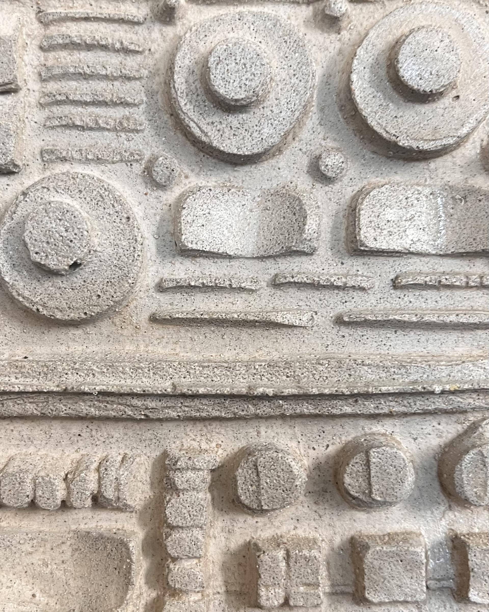 Textured concrete artwork showcasing innovative designs made from recycled plastic materials by May Wild Studio and Hopwood Hall students.