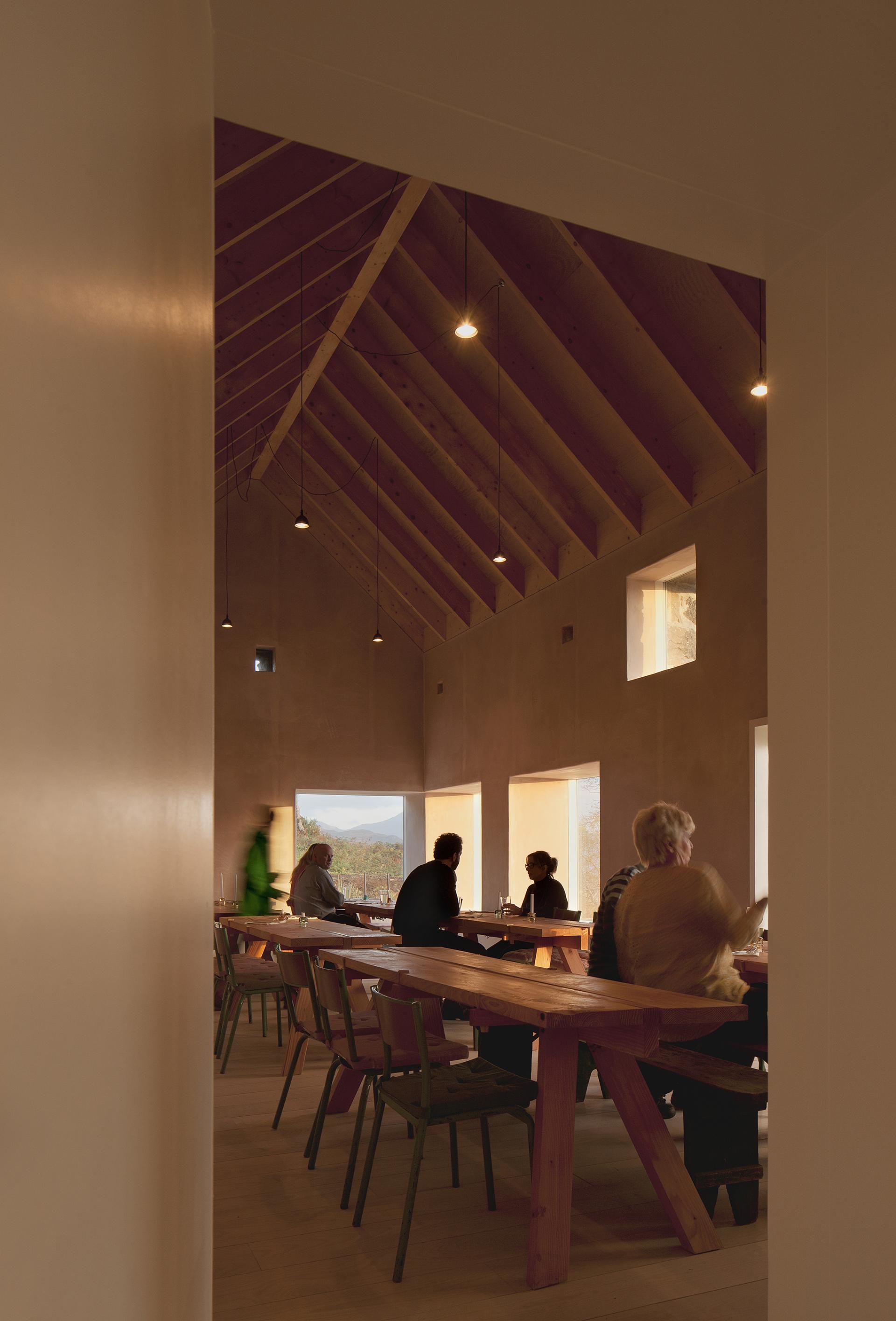 Modern dining space featuring sustainable materials, with guests enjoying conversation and natural light illuminating the room.
