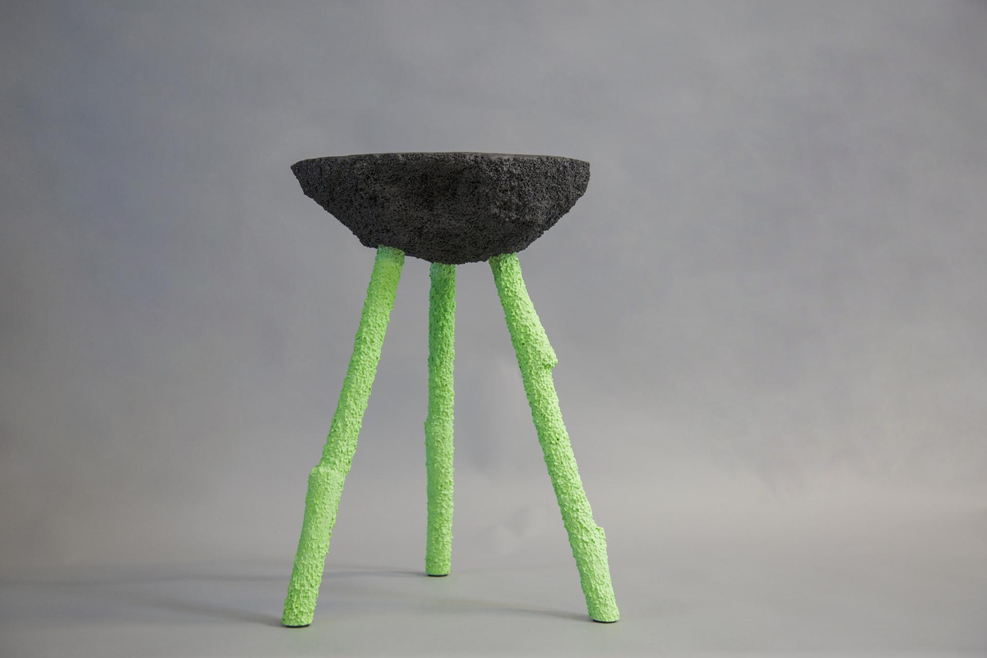 Unique art piece featuring a textured black top and vibrant green legs, part of the UK experimental artists showcase at Hauser & Wirth.