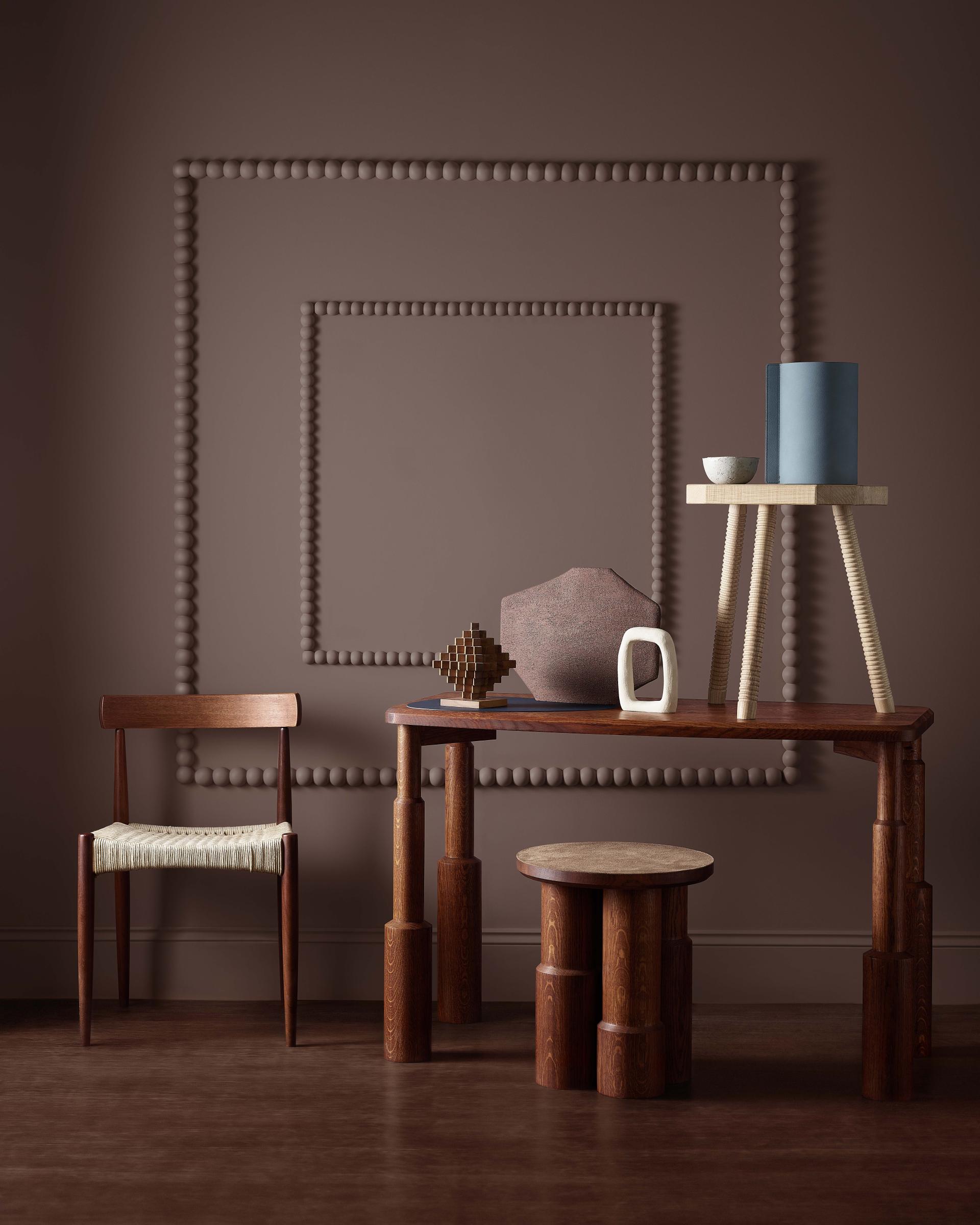 Stylish room showcasing contemporary furniture and decor against a rich, earthy brown wall, illustrating Crown Paints' Colour Insights 2024/25.