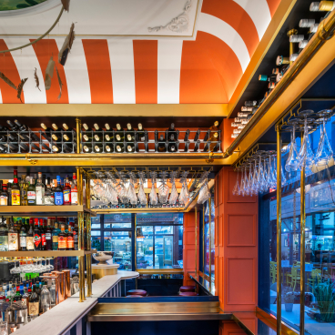 Stylish 3.5m2 bar interior in Brixton, featuring vibrant colors, decorative ceiling, and an extensive drink selection.